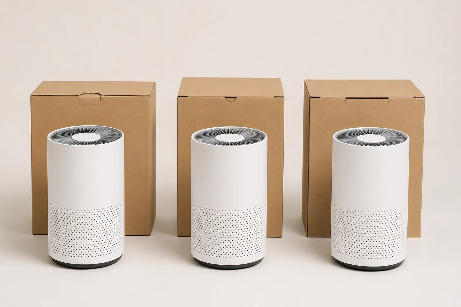 Trois purificateurs d’air blancs identiques alignés, chacun à côté d’un carton d’expédition simple et sans marque