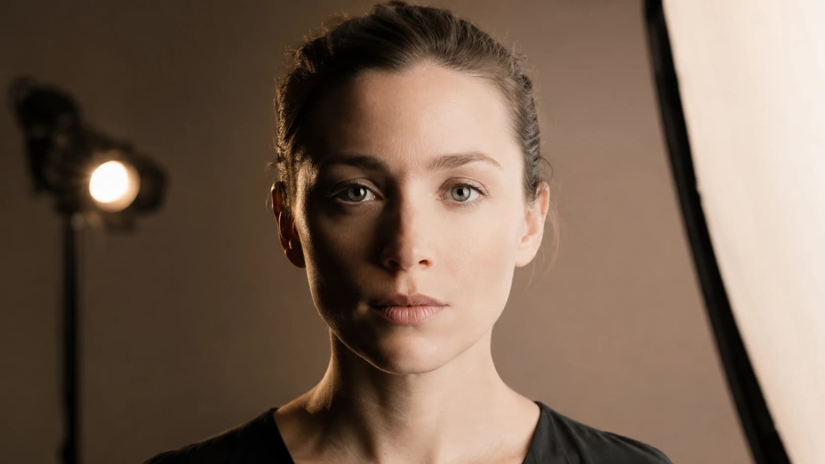 The same face photographed under hard side lighting and under flat frontal lighting, showing how shadows change the skin